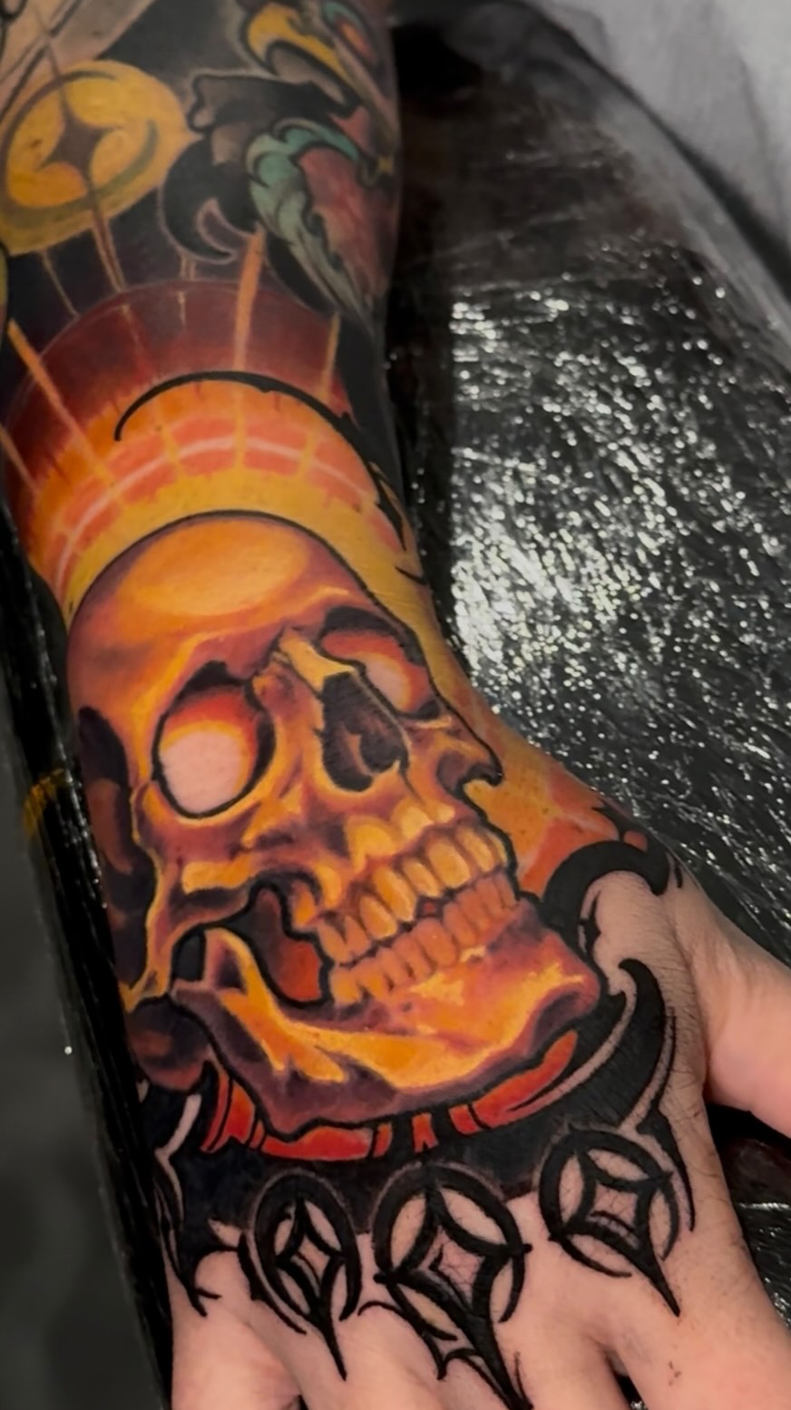Flaming skull color tattoo on hand and arm