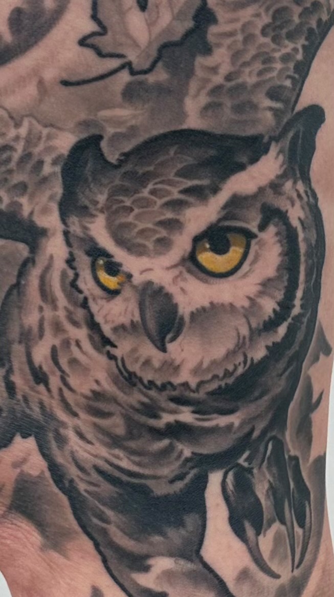 Black-and-grey owl with yellow eyes tattoo