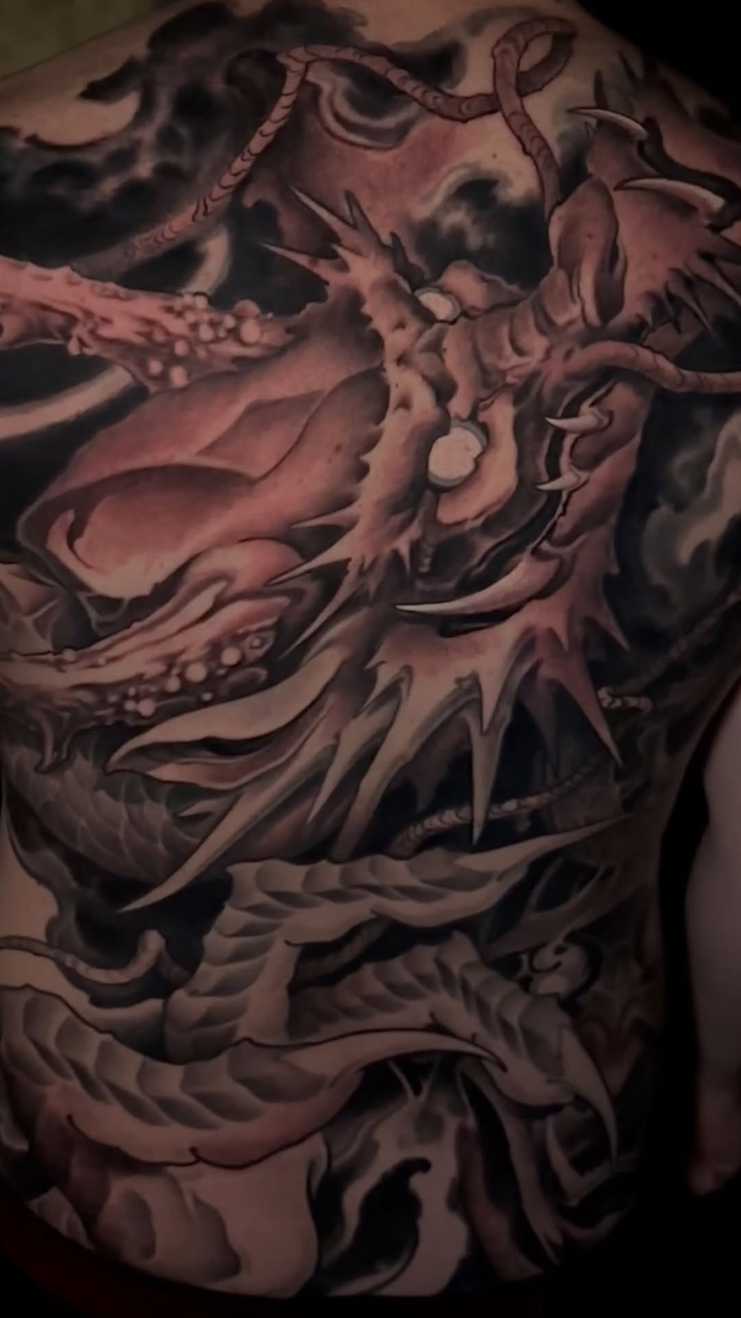 Dragon chest tattoo in black-and-grey