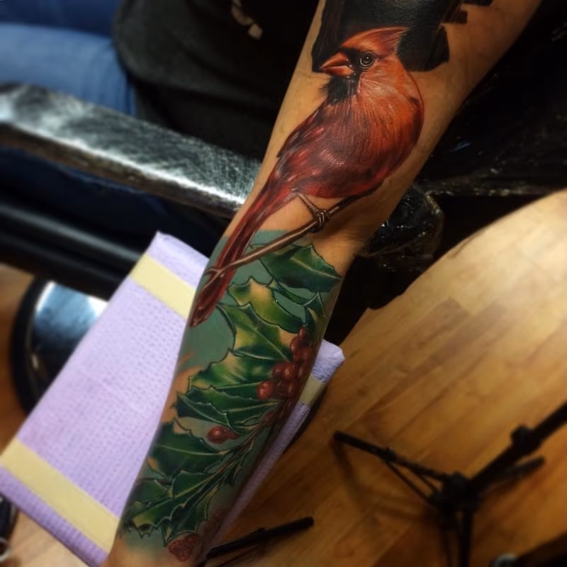 realistic color cardinal with holly tattoo. Brent Olson Art Junkies Tattoo