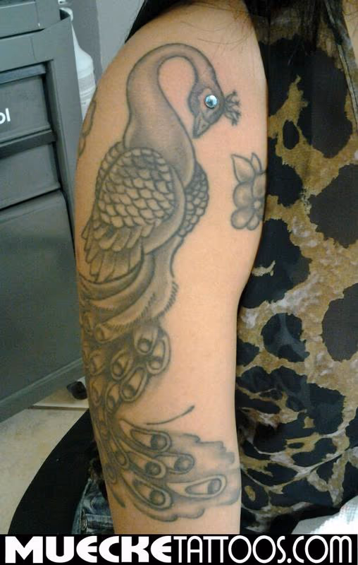 Peacock tattoo with dermal piercing