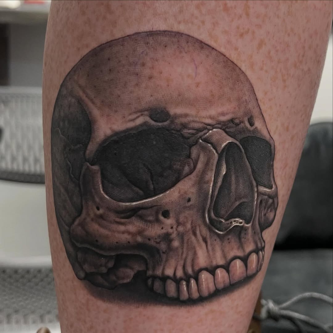 Black-and-grey skull portrait, thigh