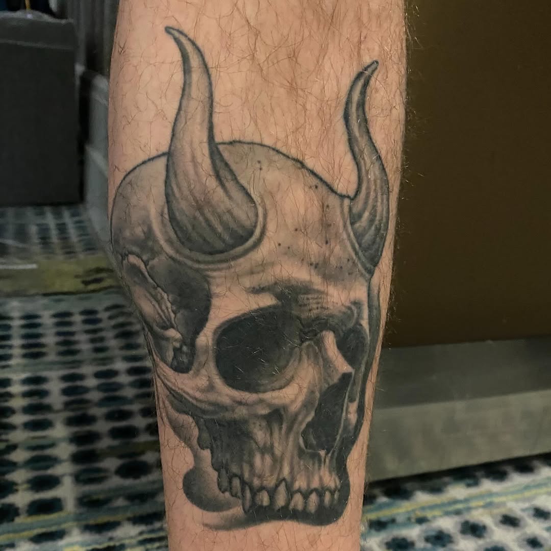 Skull with horns, black-and-grey realism, leg
