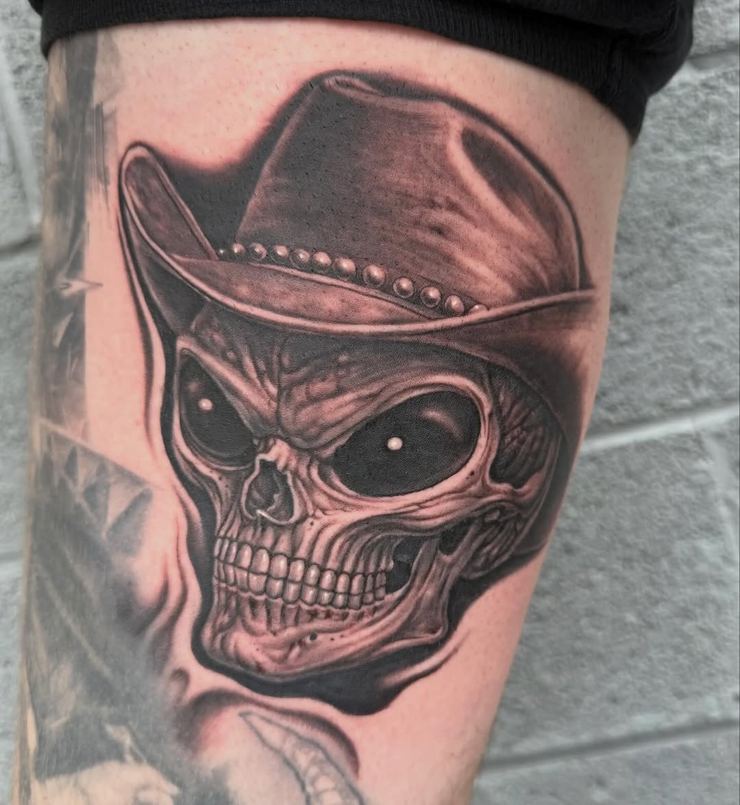 Cowboy skull with hat, black-and-grey realism, thigh