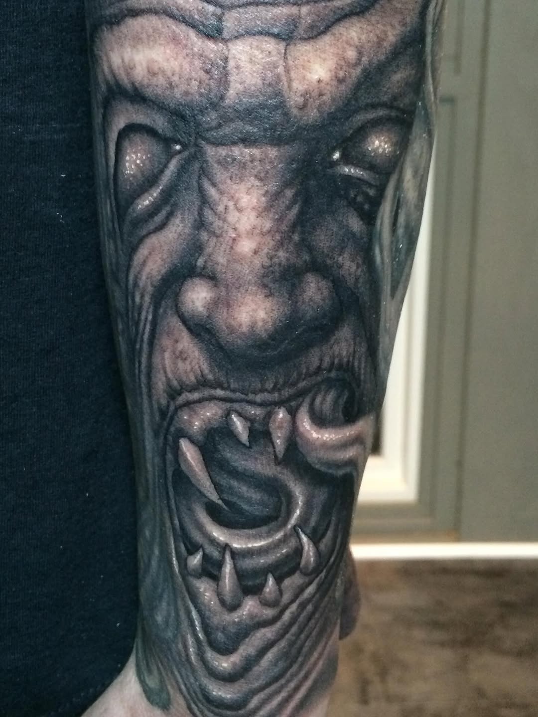 Black-and-grey demon portrait sleeve, leg