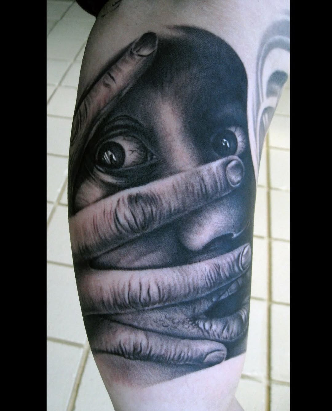 Black-and-grey surreal face with bandages, thigh