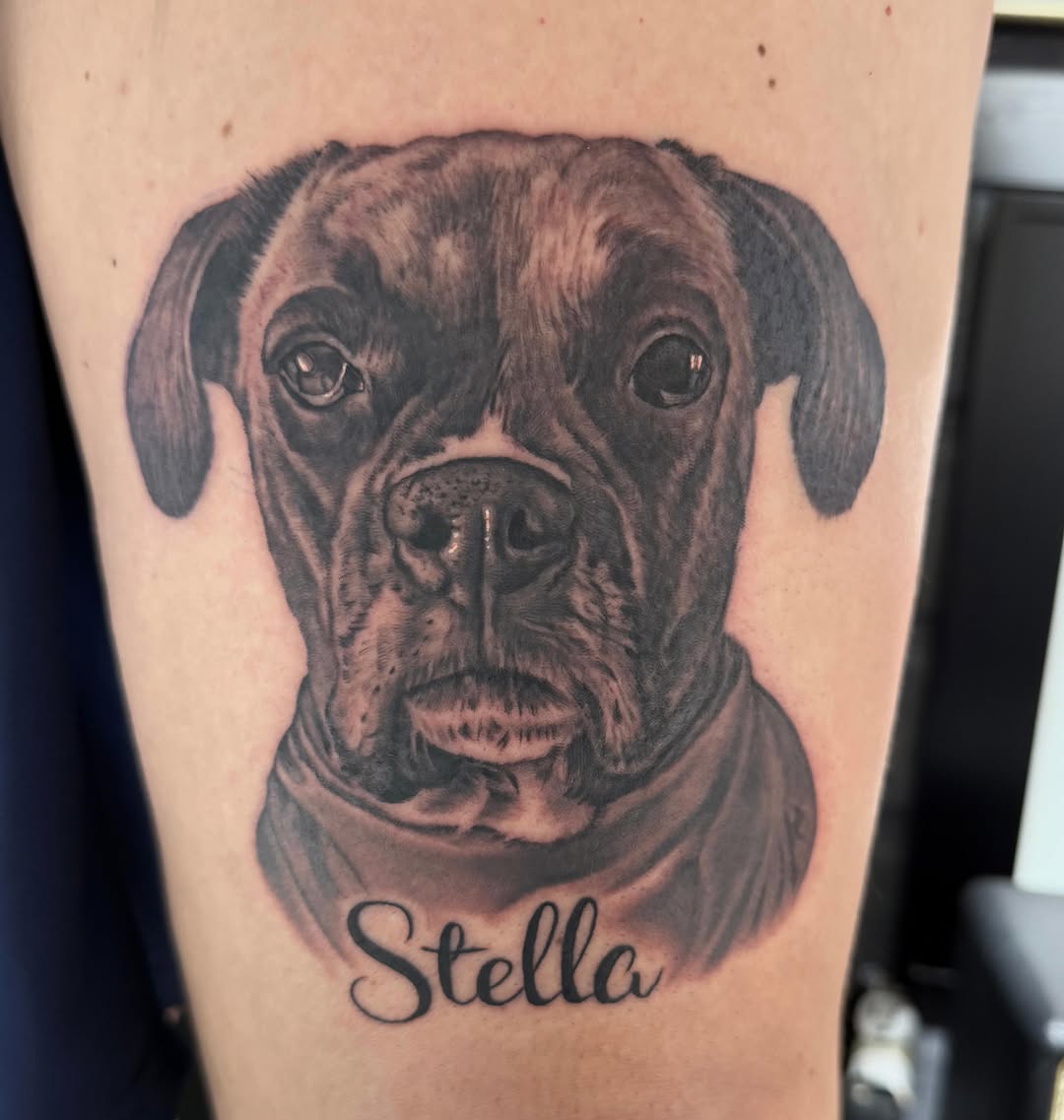 Black-and-grey dog portrait with name, upper arm