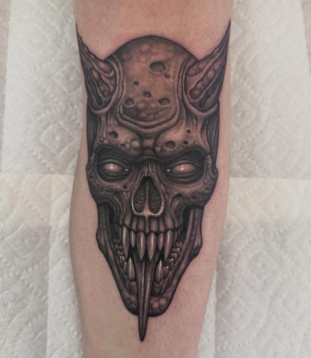Demon skull with horns and moon, shin tattoo