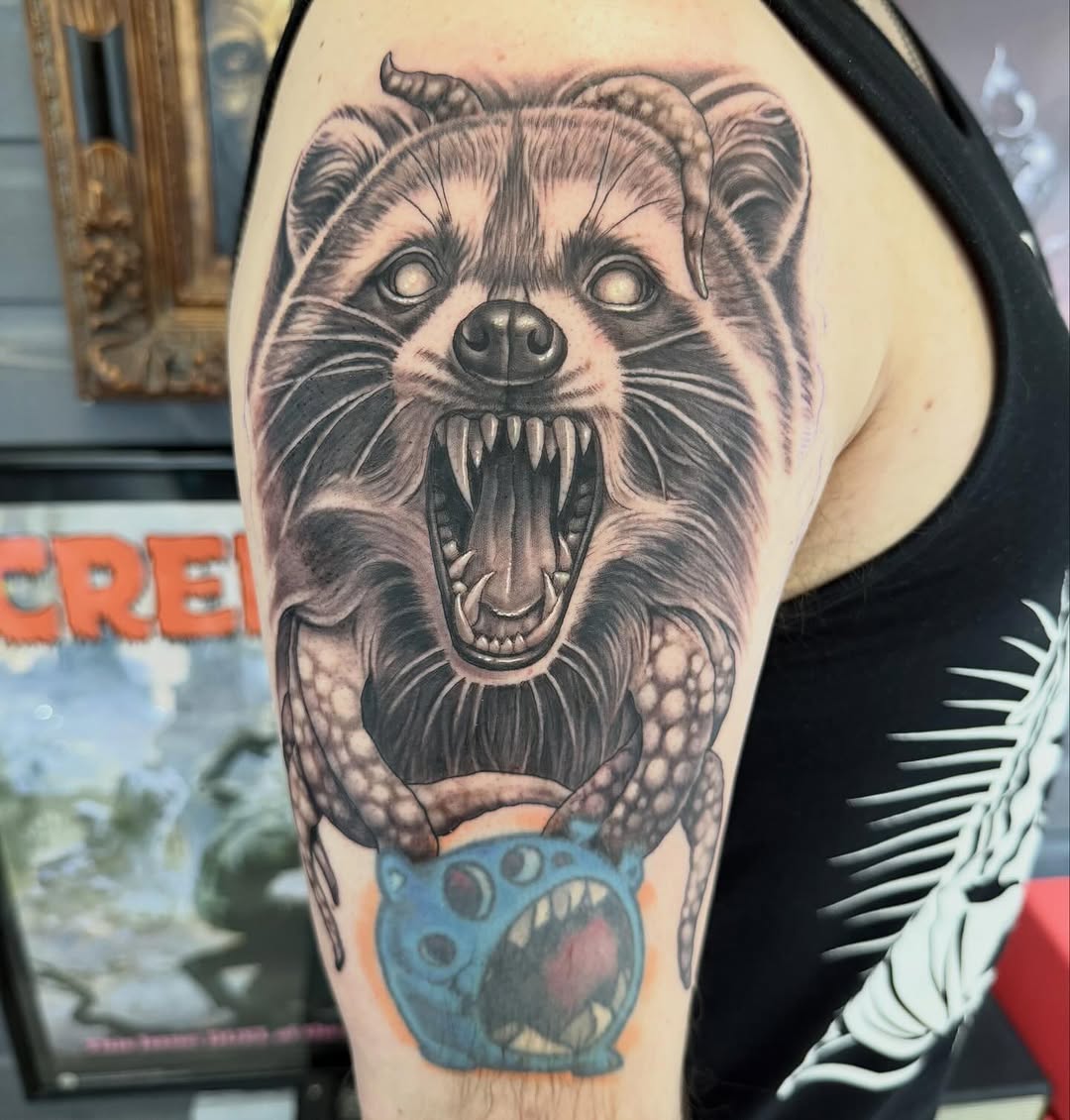 Creepy raccoon portrait tattoo on shoulder