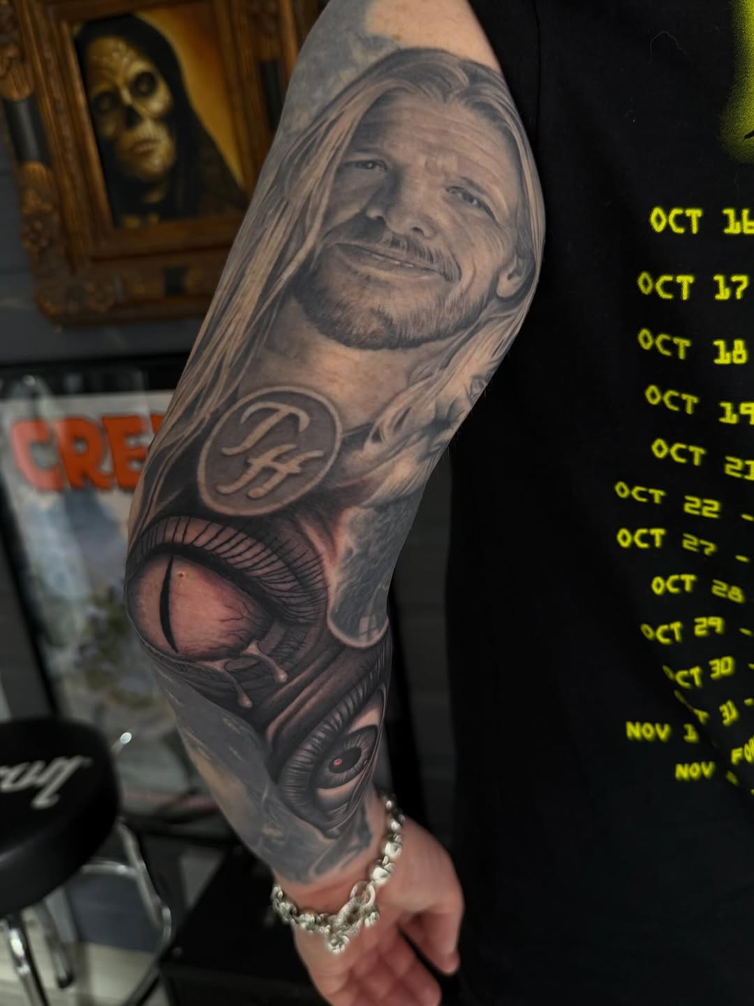 Black-and-grey portrait sleeve with eyeball detail, forearm