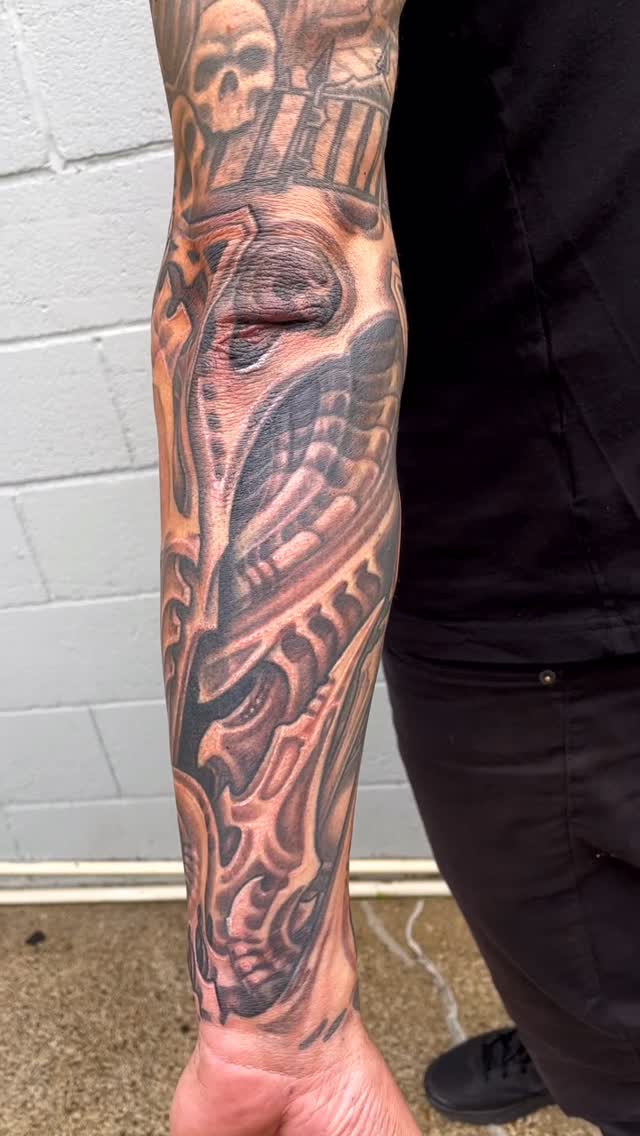 Black-and-grey biomechanical full sleeve with architecture