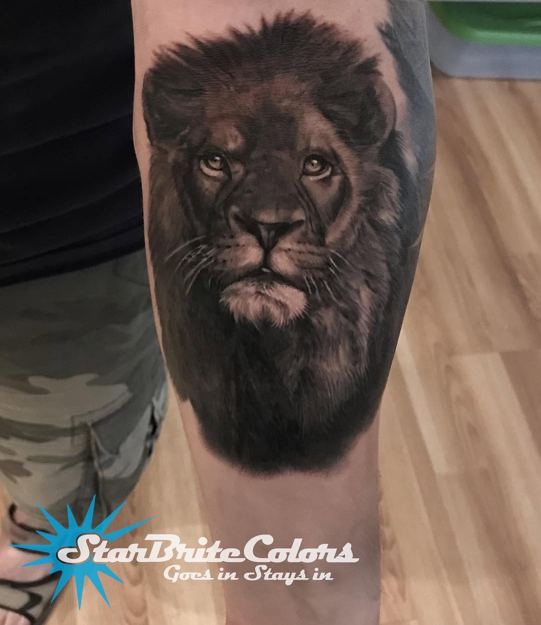 Black-and-grey lion portrait tattoo, forearm