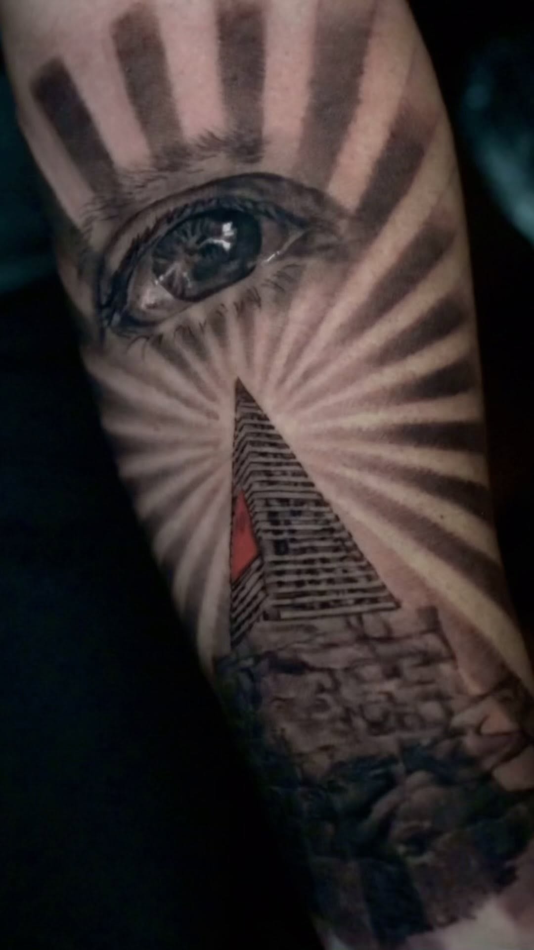Realistic eye and pyramid tattoo, arm