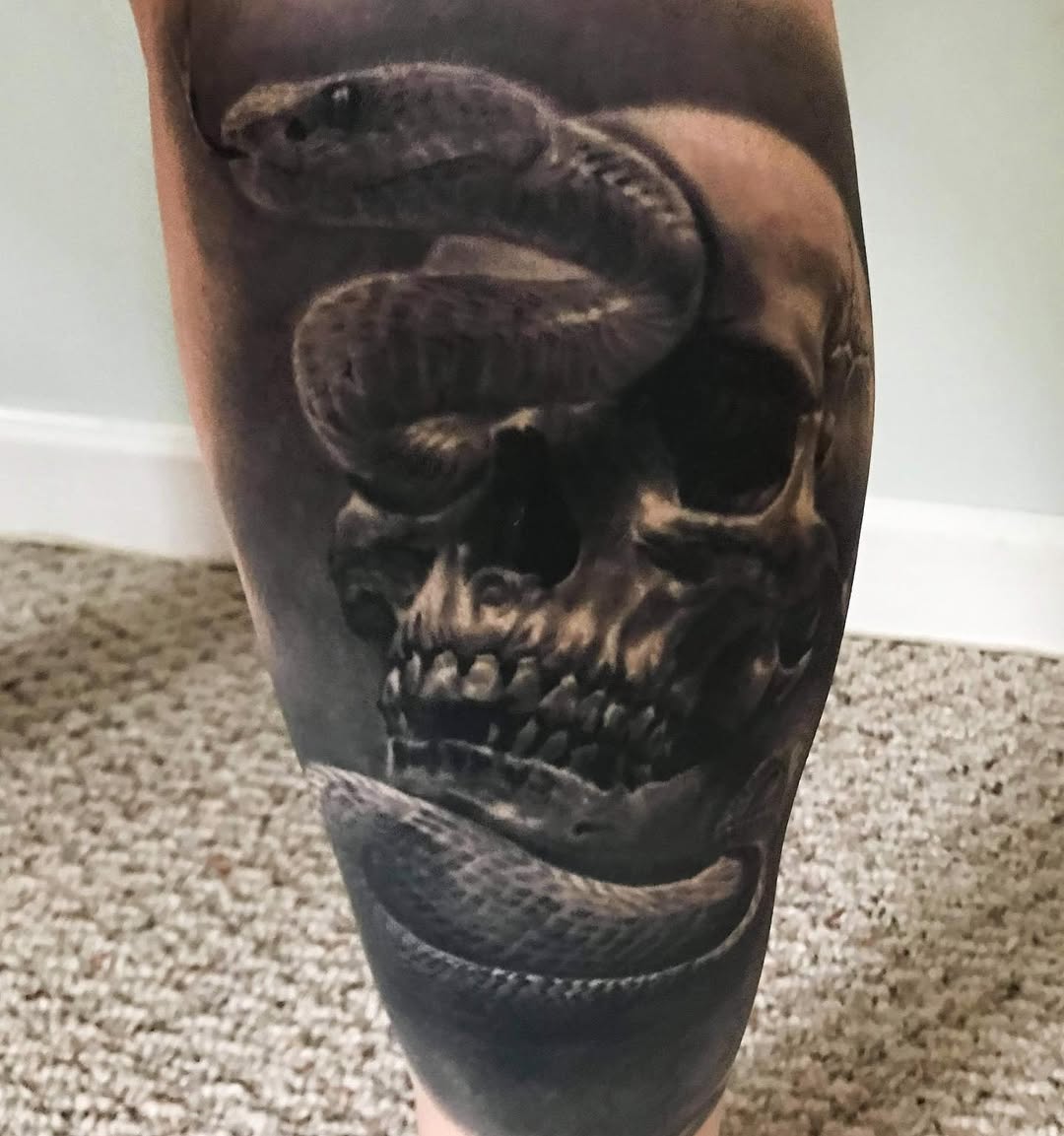 Black-and-grey skull and snake tattoo, calf