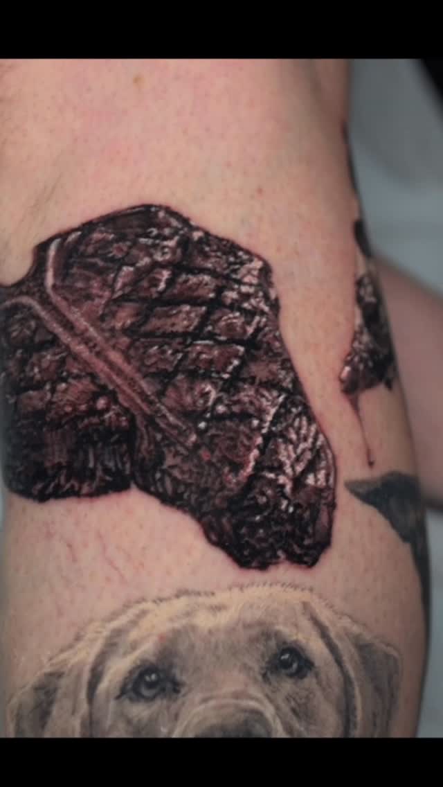 Realistic T-bone steak tattoo on leg