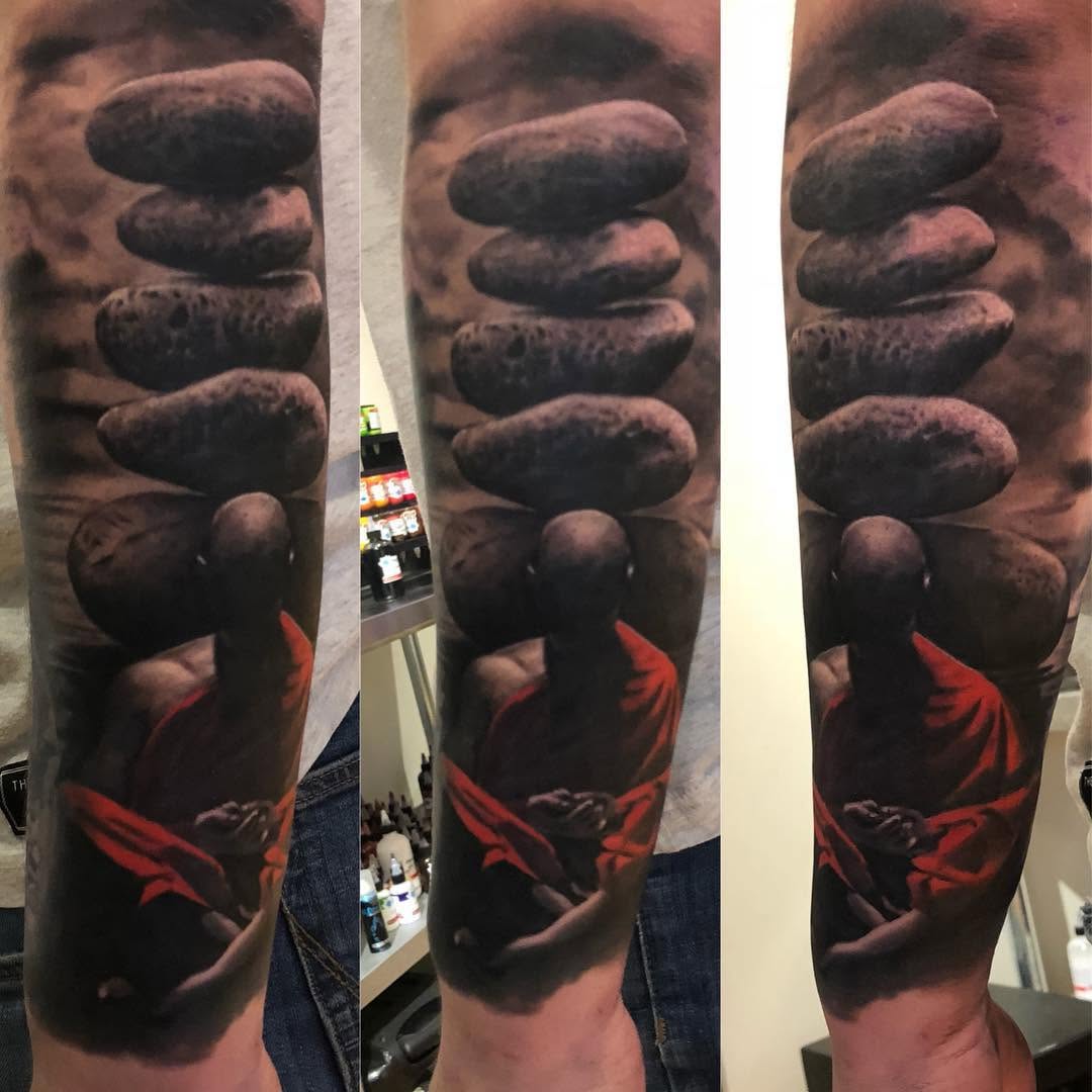Realism monk and stones forearm tattoo