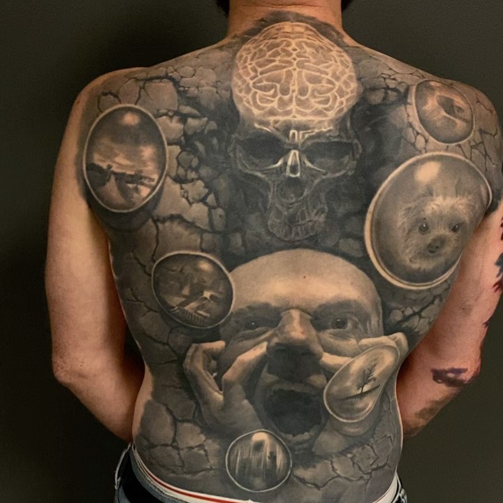 Black-and-grey skull and portrait back piece