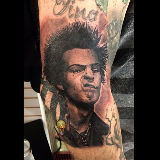 Sid Vicious black-and-grey portrait tattoo, arm