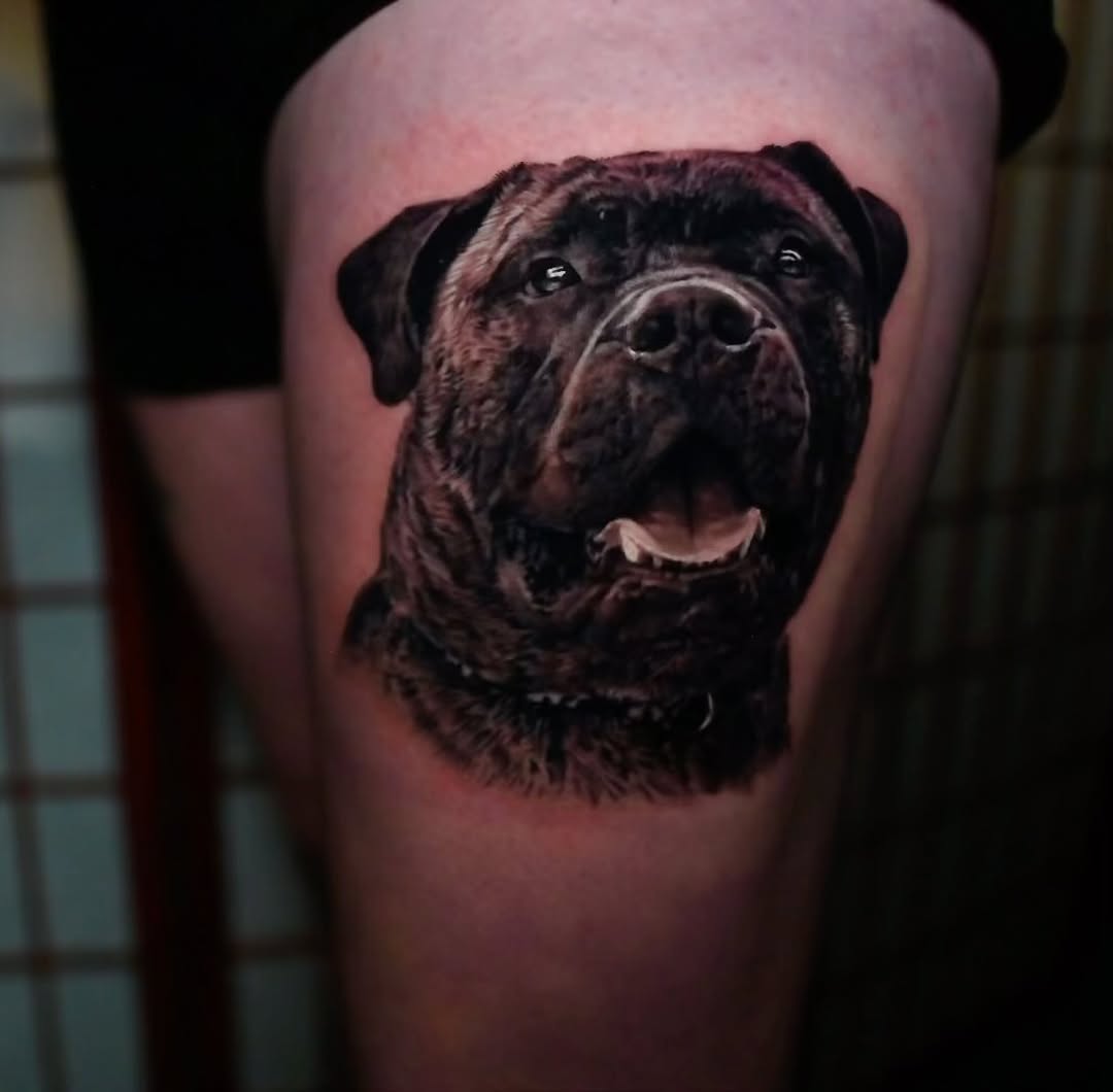 Black-and-grey dog portrait tattoo on thigh