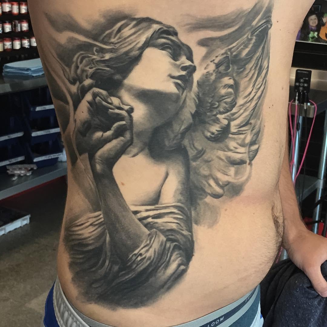 Black-and-grey praying angel tattoo, ribs