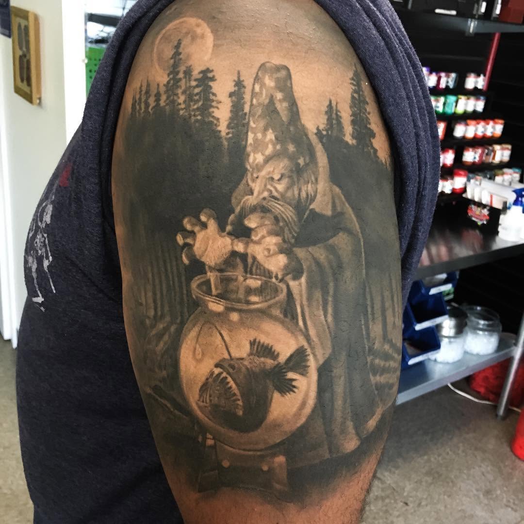 Black-and-grey wizard and anglerfish tattoo, arm