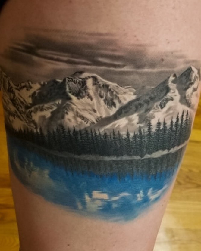 Realistic mountain lake landscape tattoo, thigh