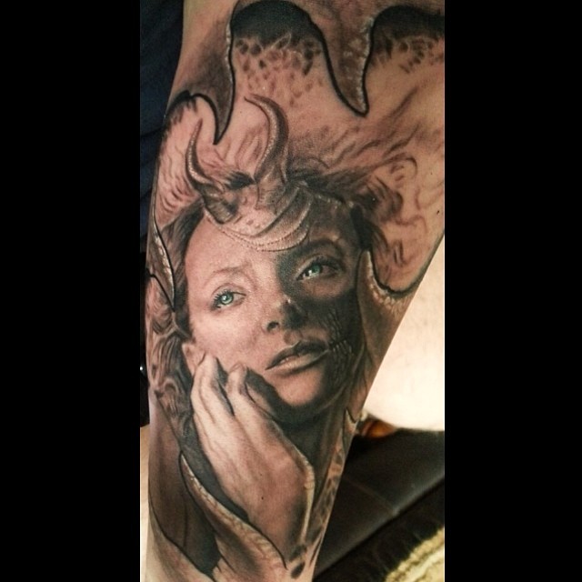 Black-and-grey horned demoness portrait tattoo