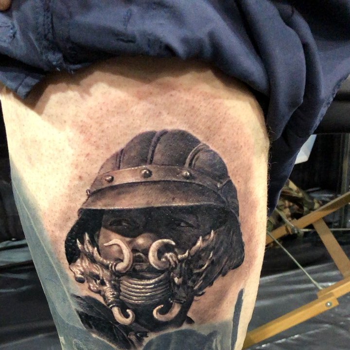Black-and-grey tribal warrior portrait, thigh