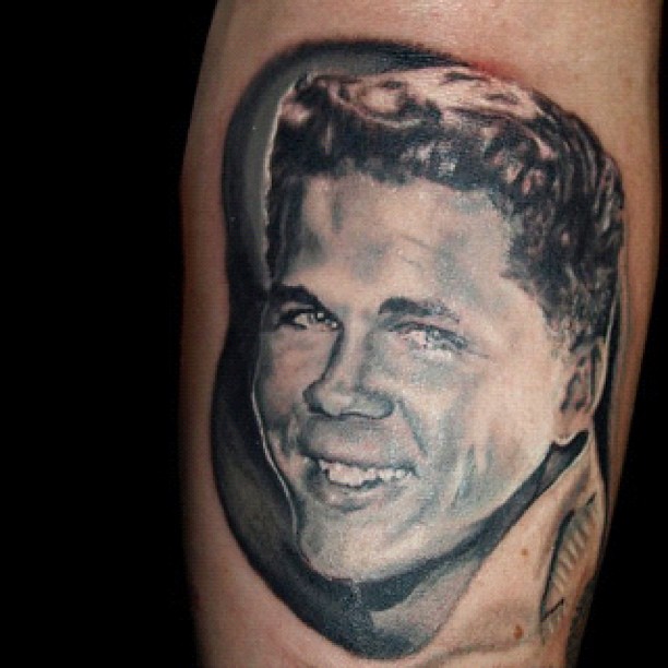 Black-and-grey portrait tattoo on forearm