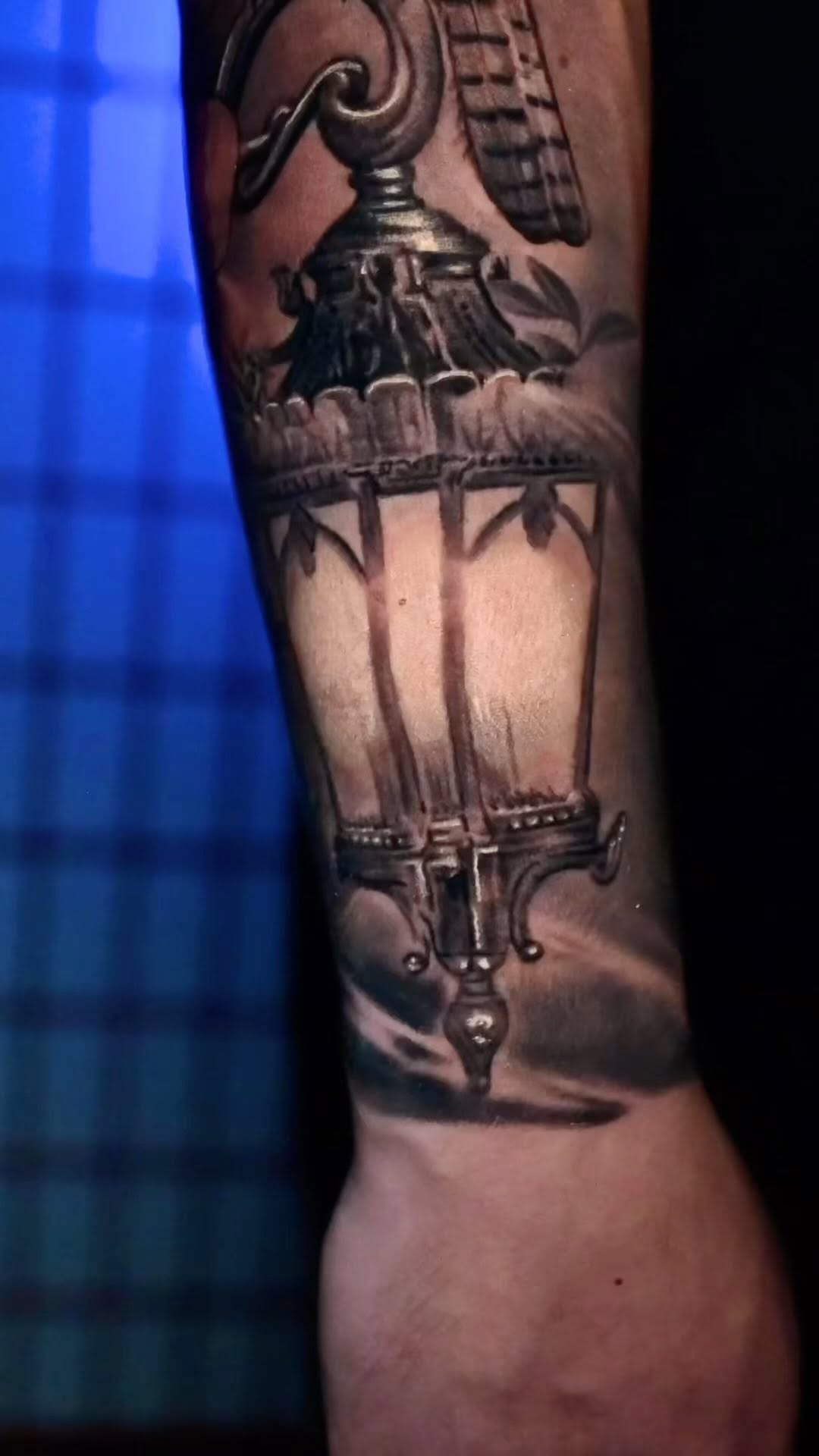 Black-and-grey lantern tattoo on forearm
