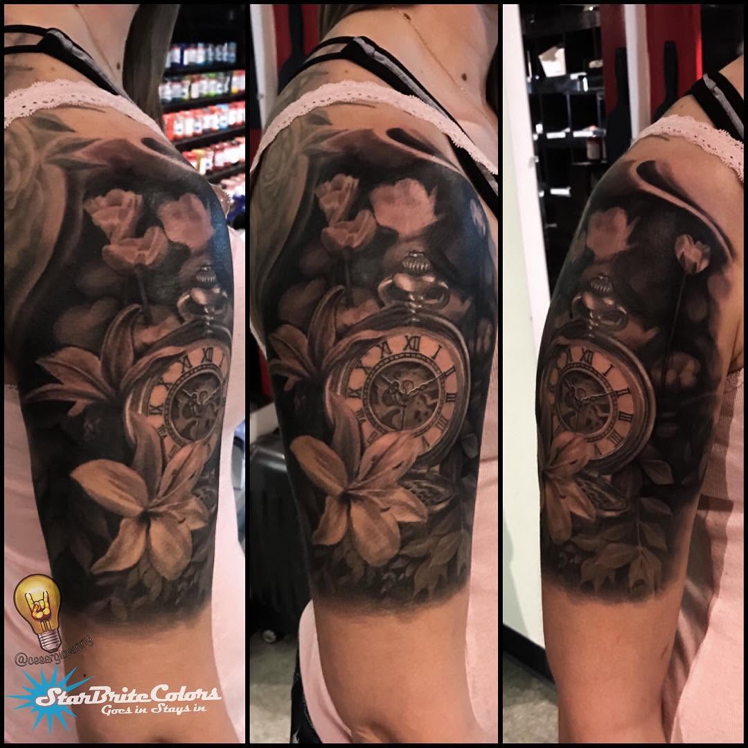 Black-and-grey pocket watch and lilies half-sleeve