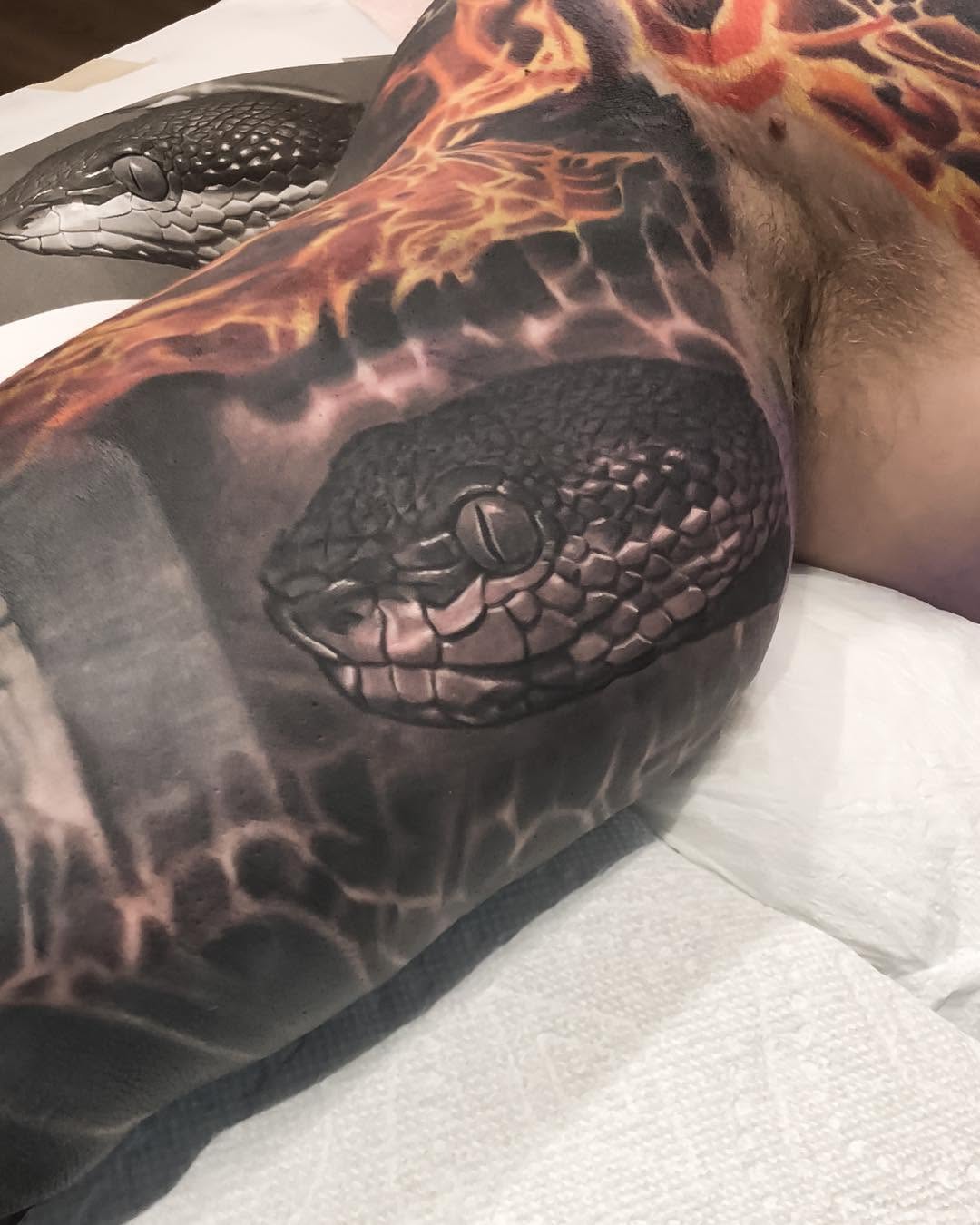 Realistic snake head with fire, chest and arm