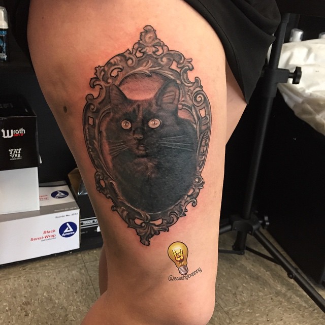 Black cat portrait in ornate frame, thigh