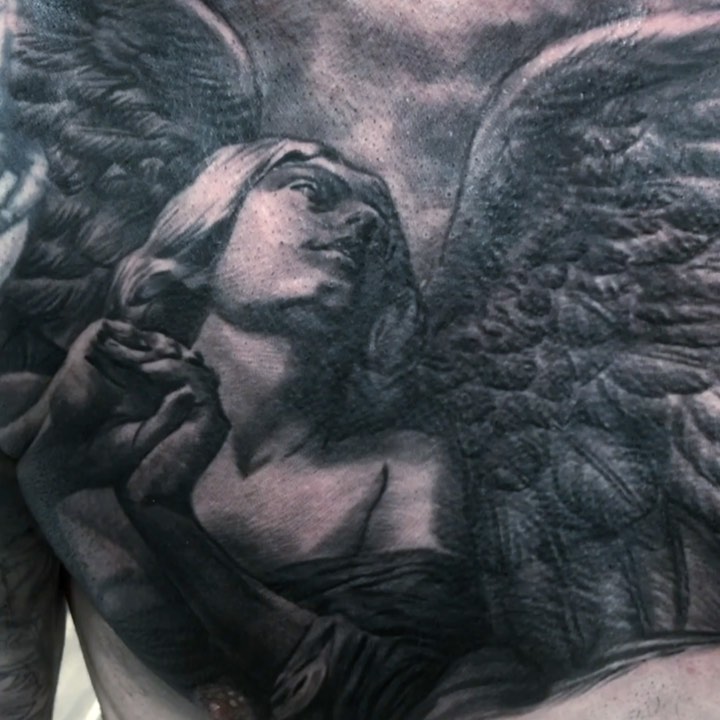Black-and-grey angel statue chest tattoo