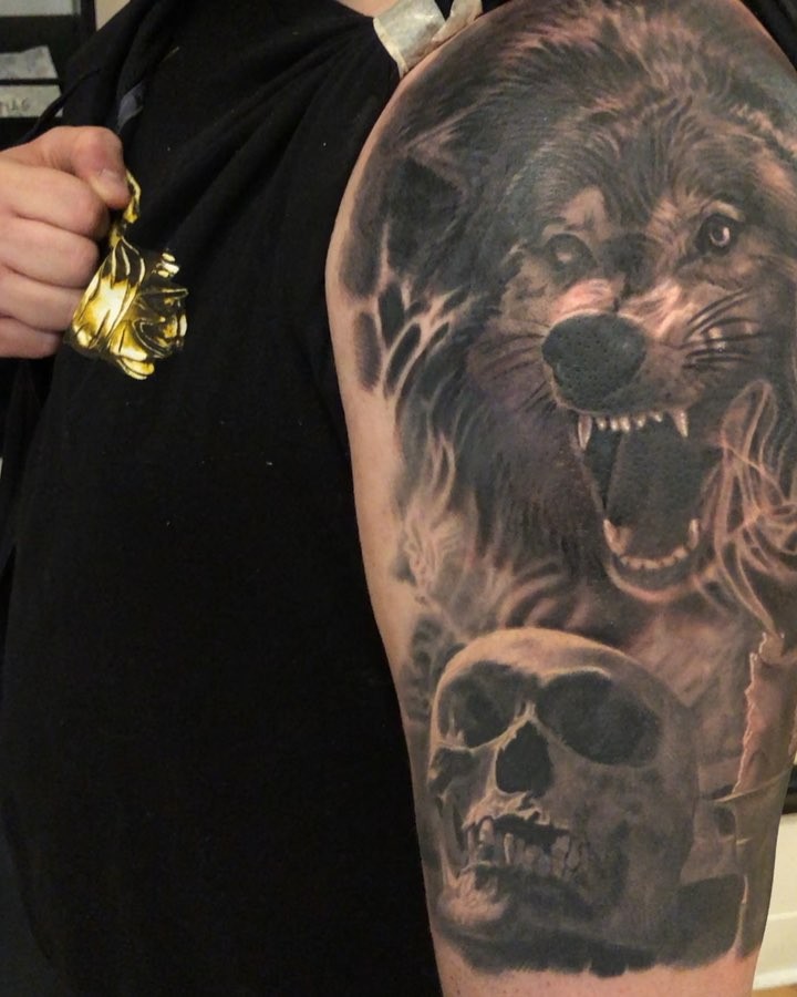 Black-and-grey wolf and skull half sleeve