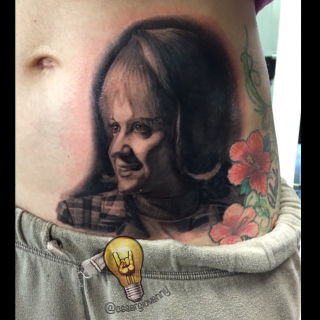 Black-and-grey portrait tattoo on stomach