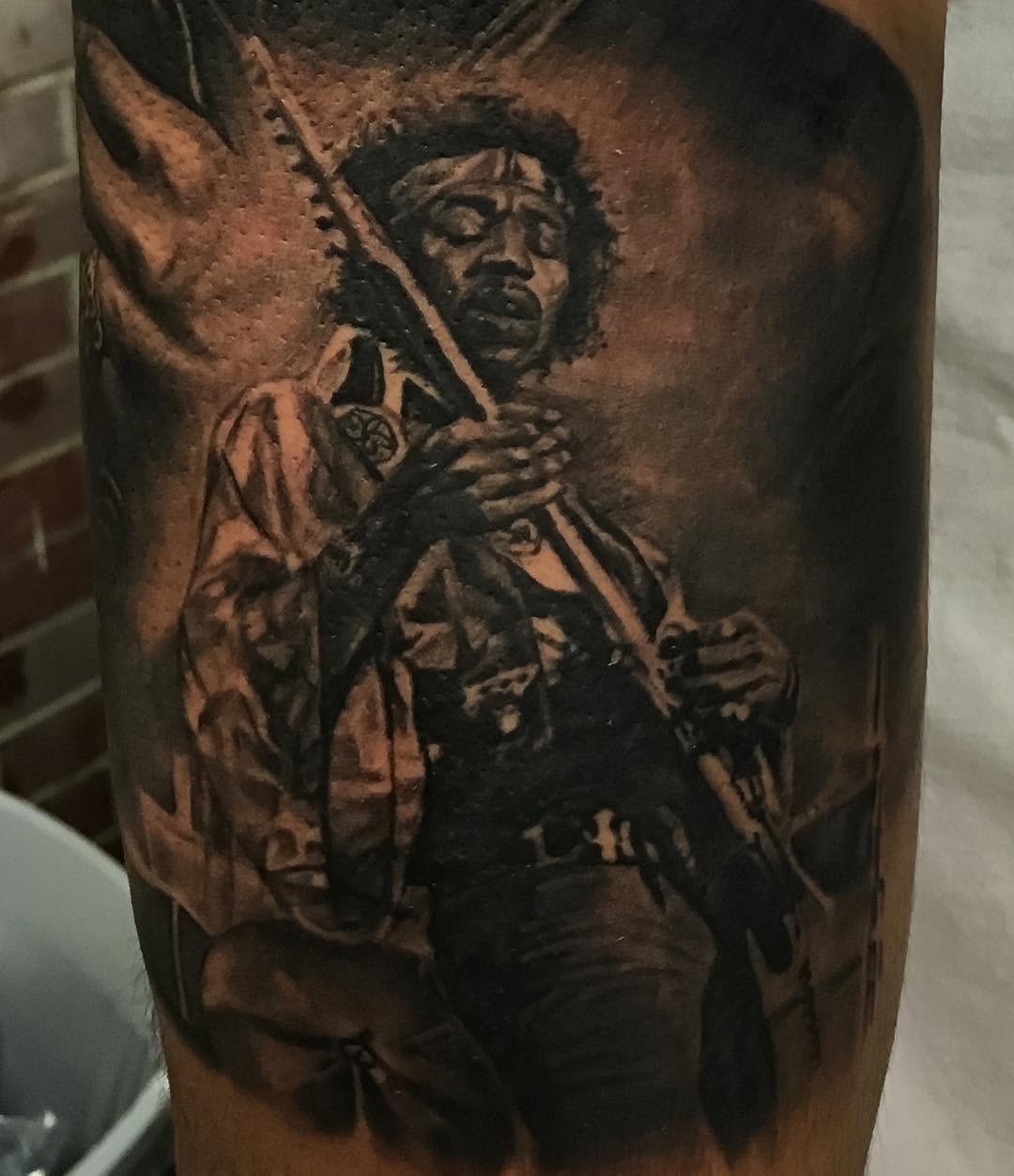 Black-and-grey Jimi Hendrix portrait tattoo