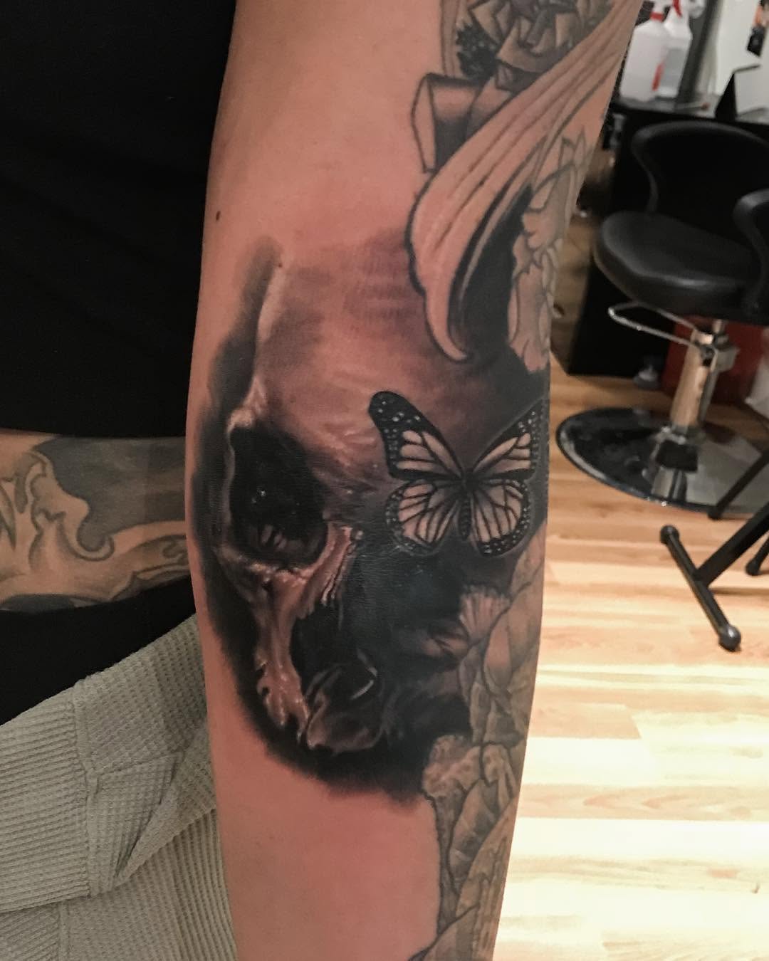 Black-and-grey skull and butterfly, forearm