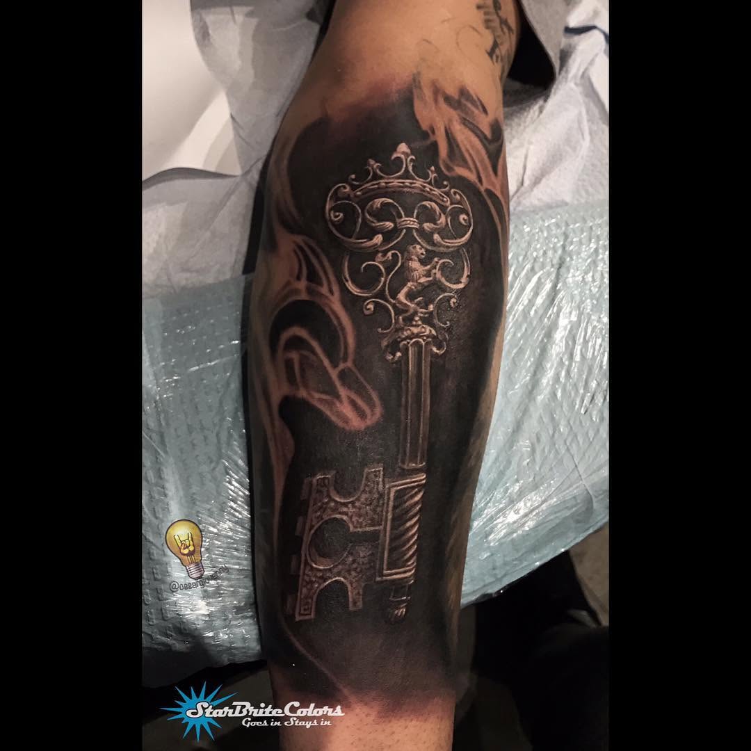 Black-and-grey ornate skeleton key, forearm