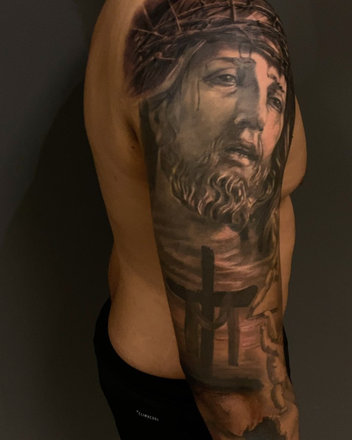 Black-and-grey Jesus portrait sleeve tattoo