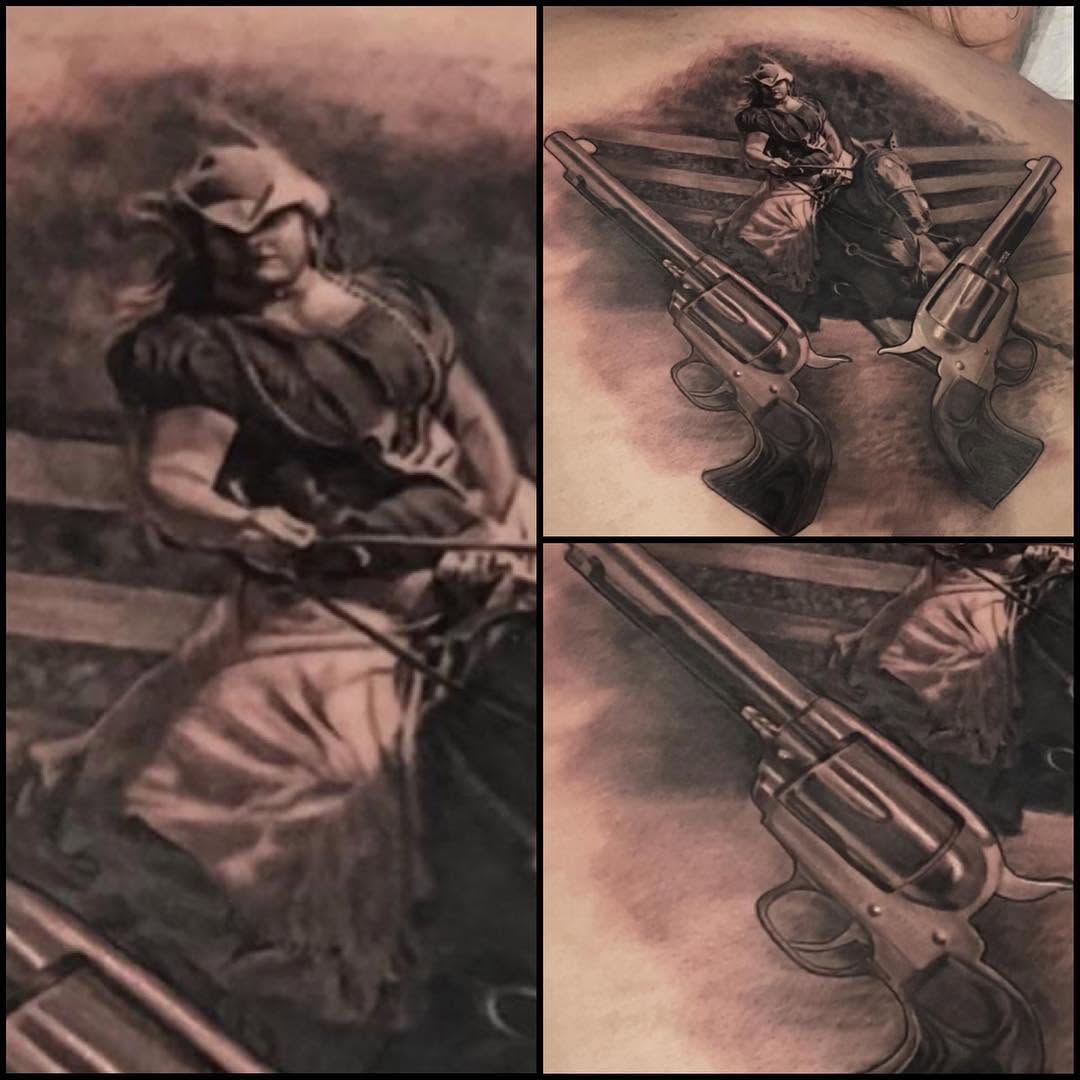 Black-and-grey cowgirl and revolvers tattoo