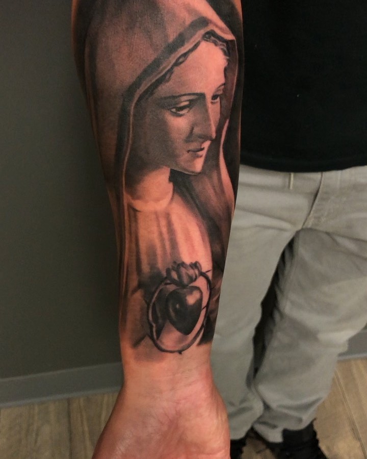 Black-and-grey Virgin Mary forearm tattoo
