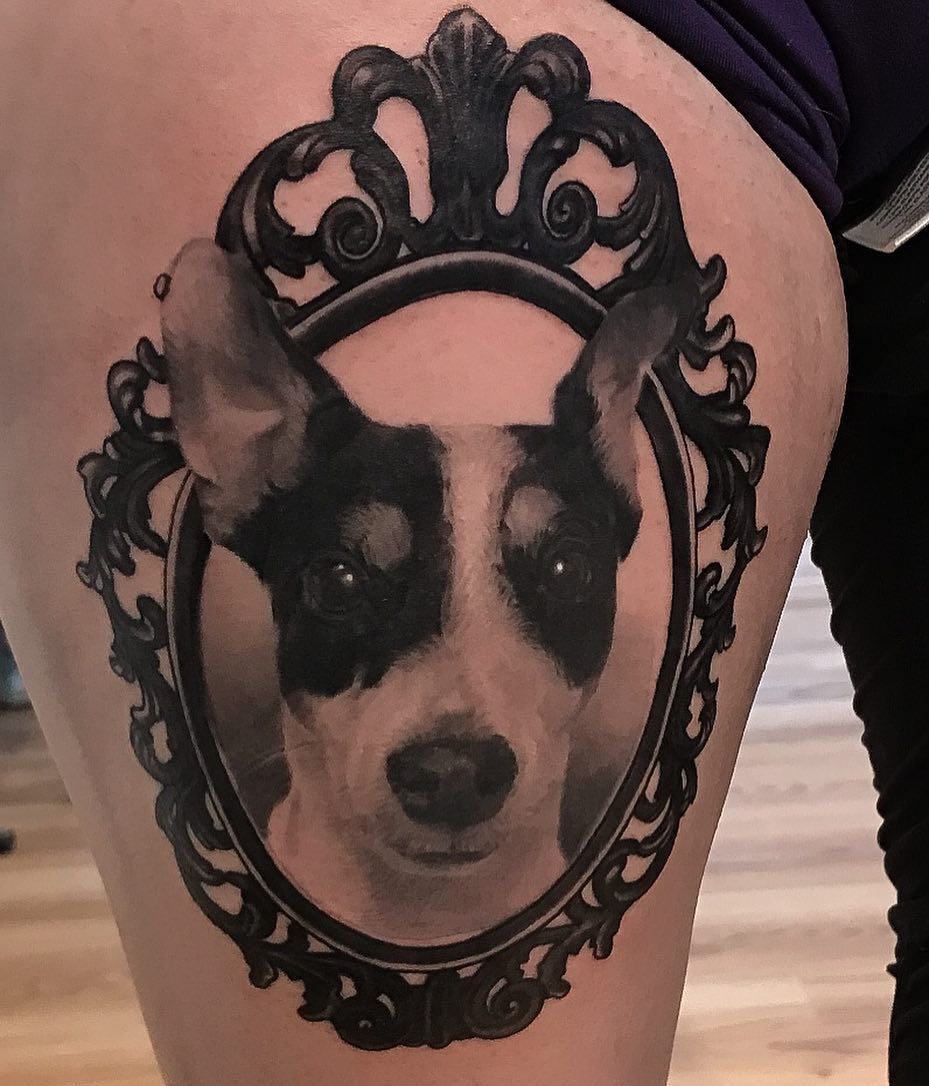 Framed dog portrait tattoo, thigh