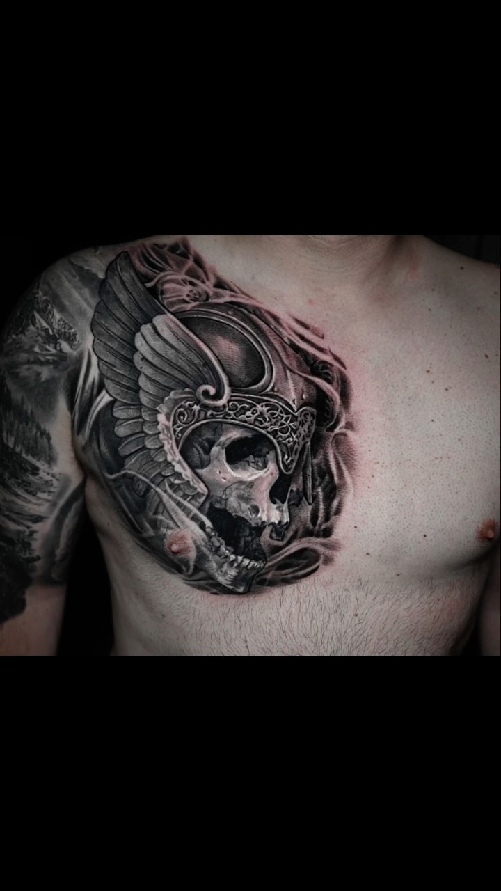 Viking winged skull chest tattoo, black-and-grey