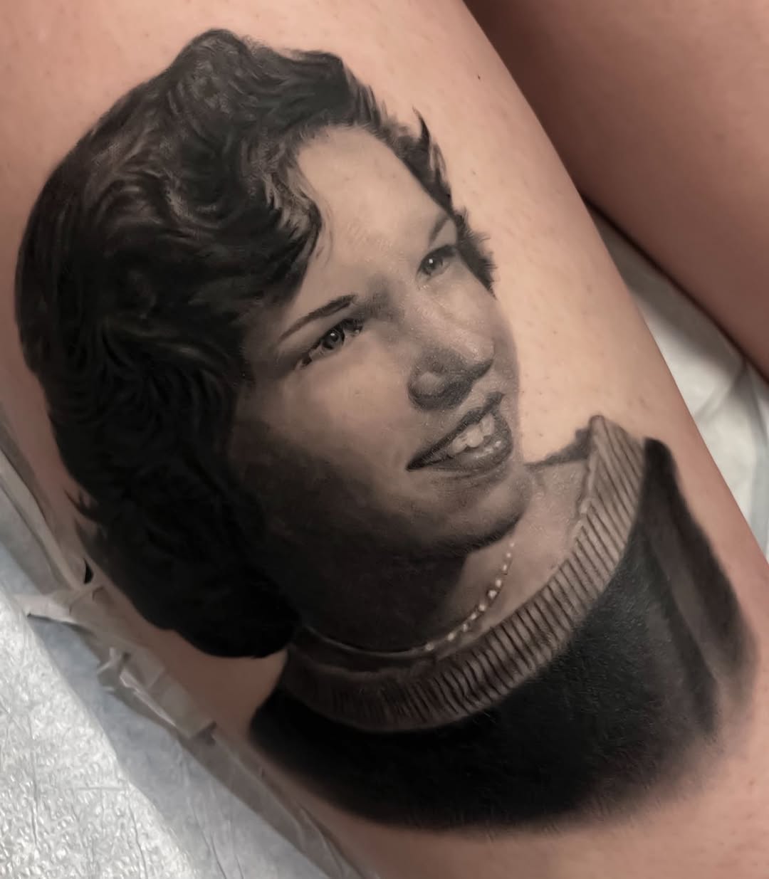 Black-and-grey vintage portrait tattoo, thigh