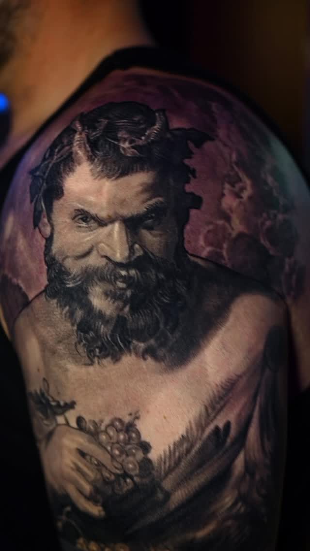 Black-and-grey satyr portrait tattoo, bicep