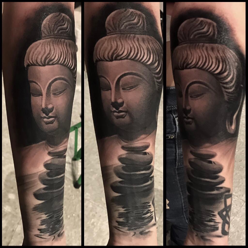 Black-and-grey Buddha and stacked stones, forearm