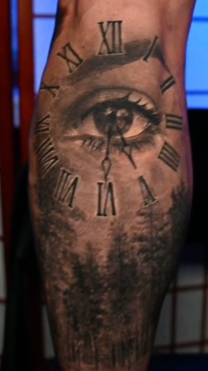 Realistic eye and clock tattoo on calf