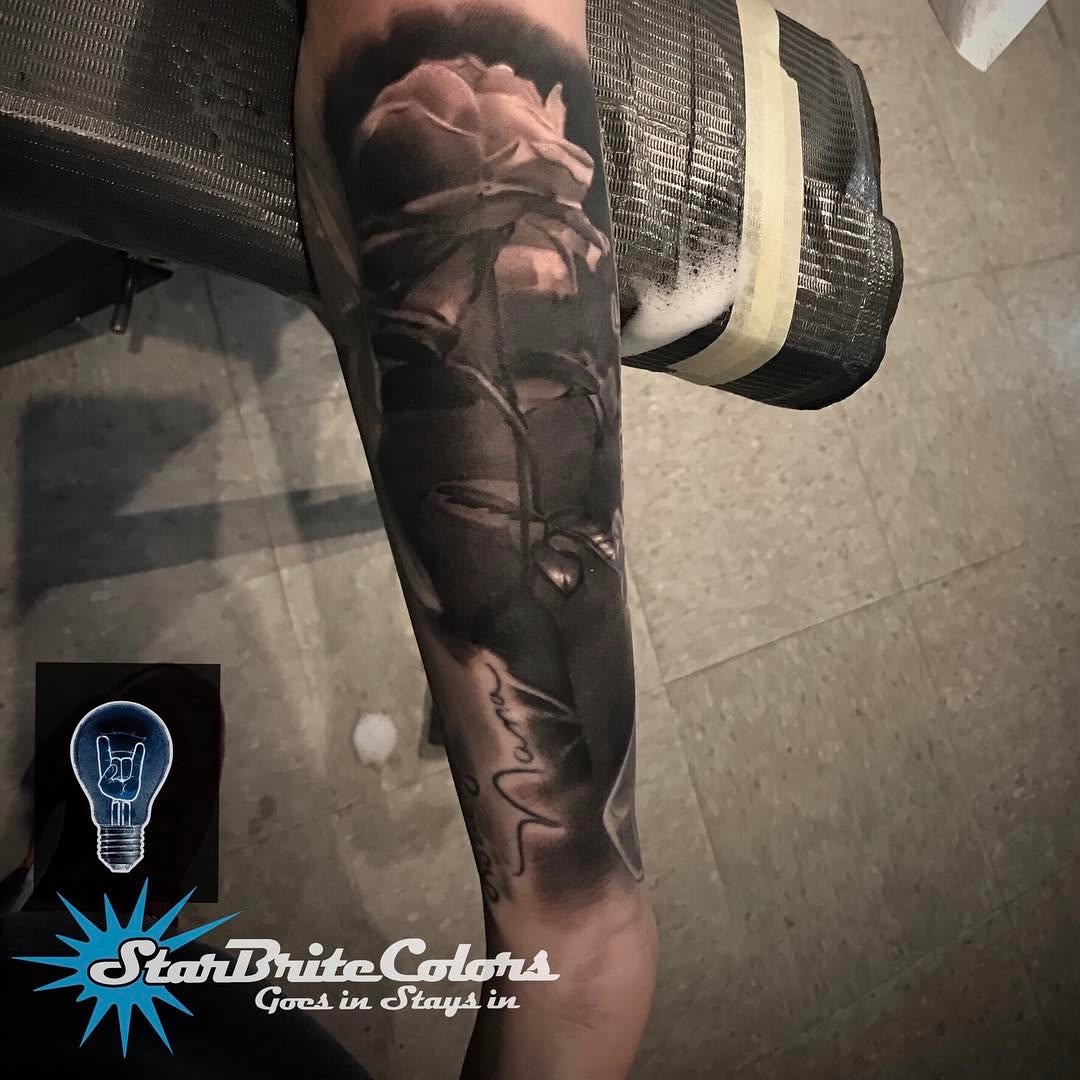 Black-and-grey realism rose tattoo on forearm