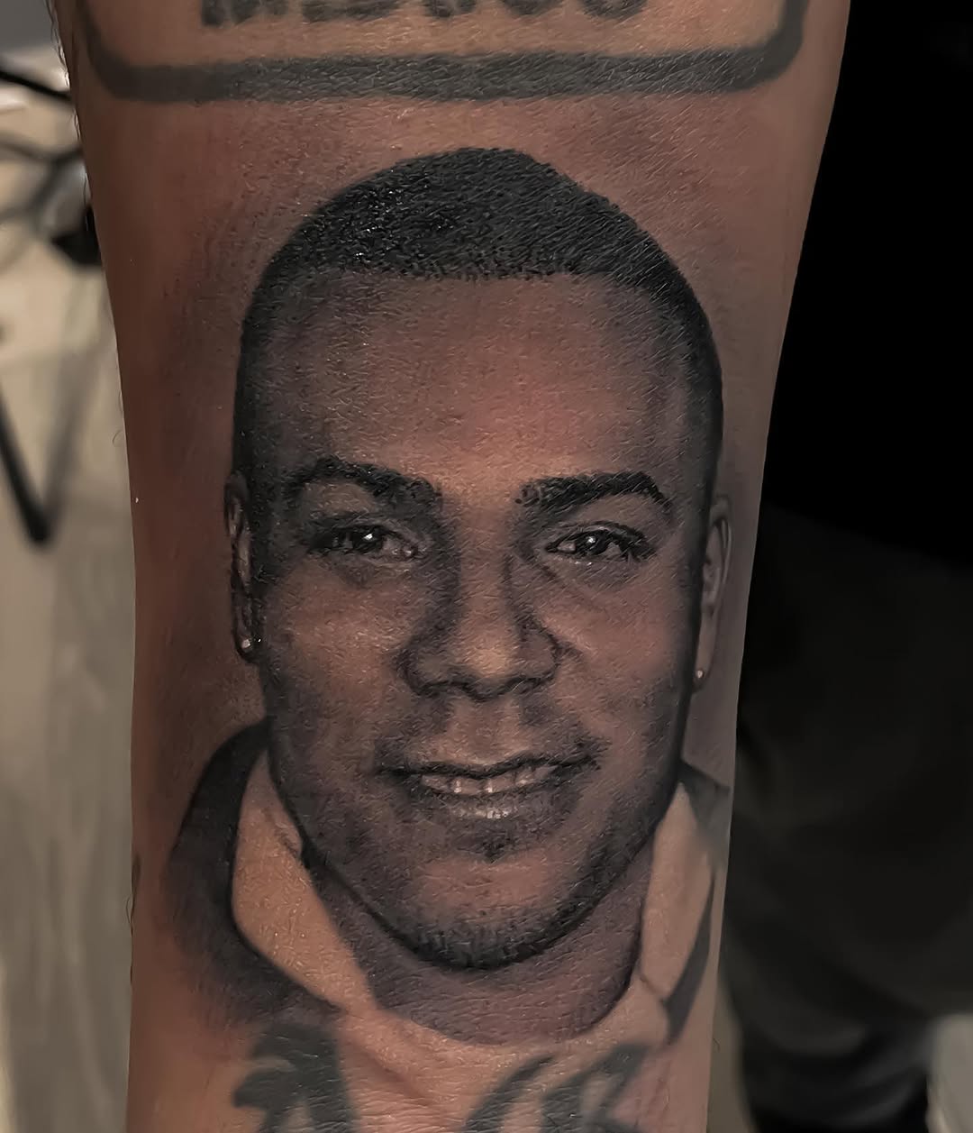 Black-and-grey memorial portrait, forearm